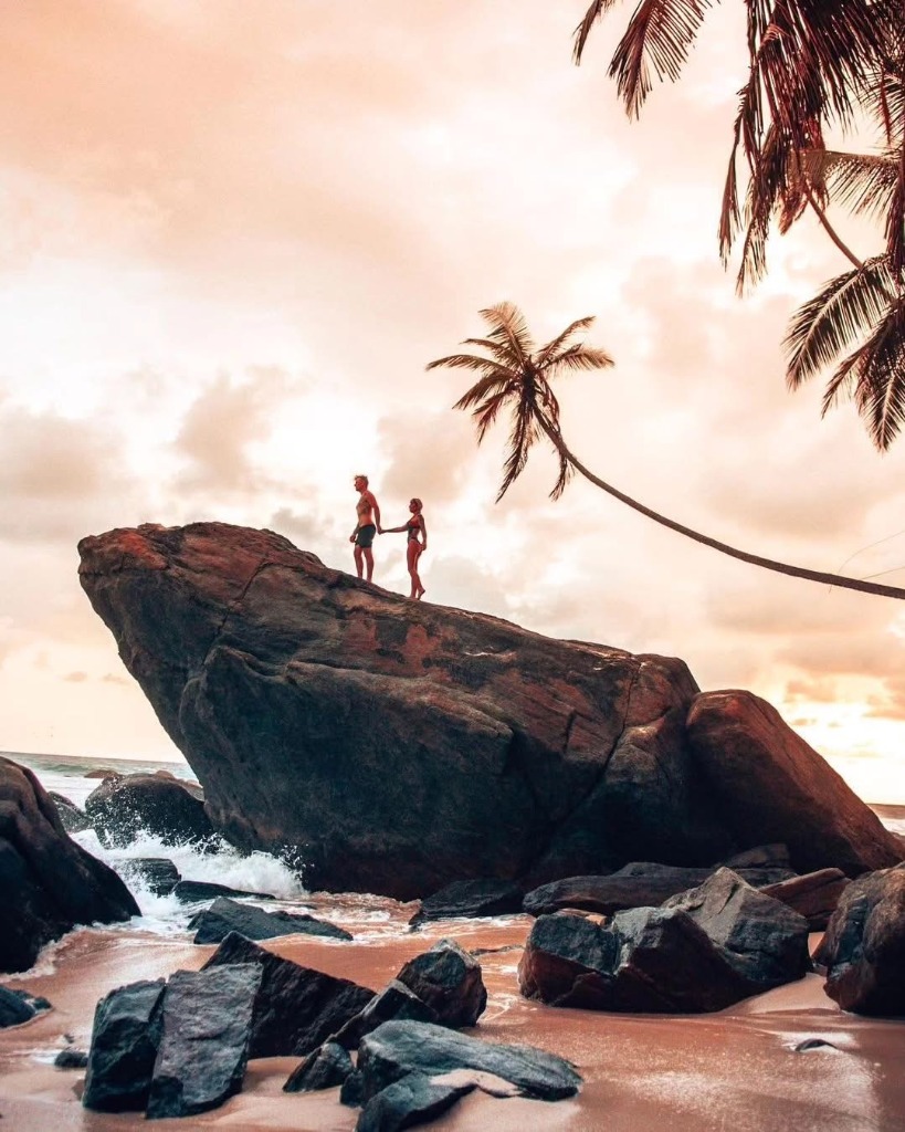 Couple on Coastal Rock at Sunset